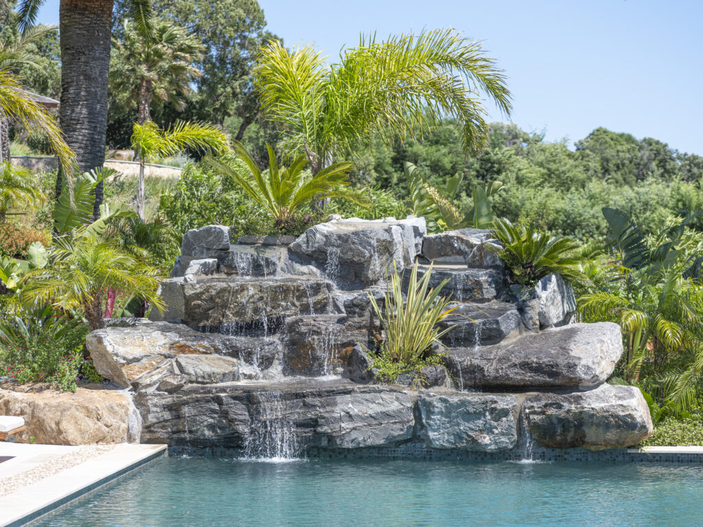 Cascade artificielle réalisée par Adonis Paysages, s'écoulant dans une piscine