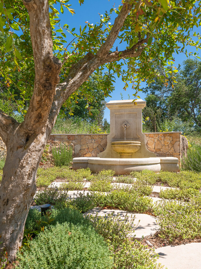 Landscaped garden with herbs and a stone fountain