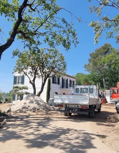 House entrance under construction with vehicles, materials and earthworks