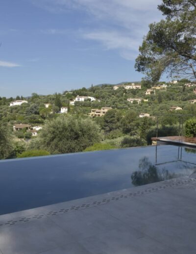 Renovated infinity pool with modern deck and open hillside view