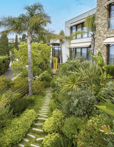 Jardin en pente luxuriant avec vue sur la maison moderne en hauteur