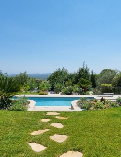 Aménagement paysager terminé avec piscine, massifs méditerranéens et murs blancs rénovés