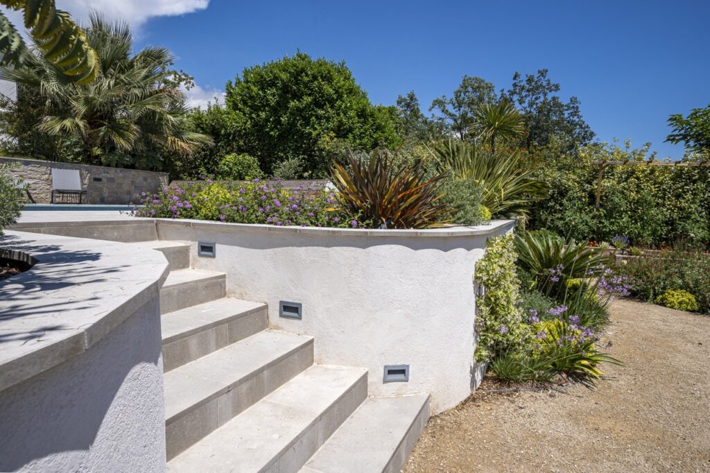 Outdoor stone staircase surrounded by flower beds and Mediterranean plants