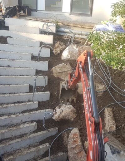 Installation de marches en béton sur un terrain en pente lors de l’aménagement du jardin.