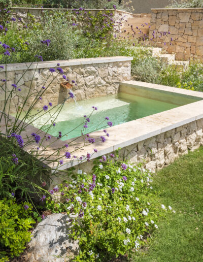 Traditional washbasin reimagined as a stone water basin, echoing the villa’s materials