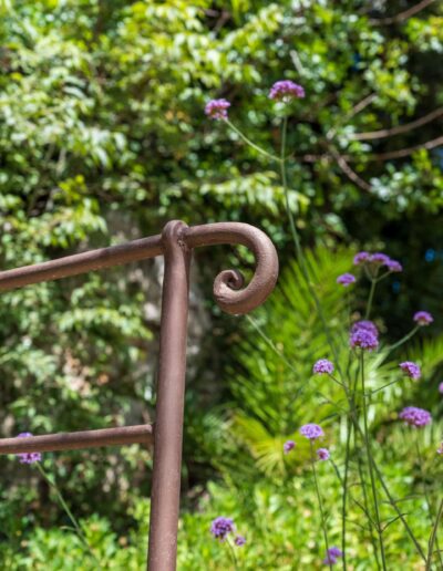 Detail of the wrought-iron railing integrated into the Mediterranean garden
